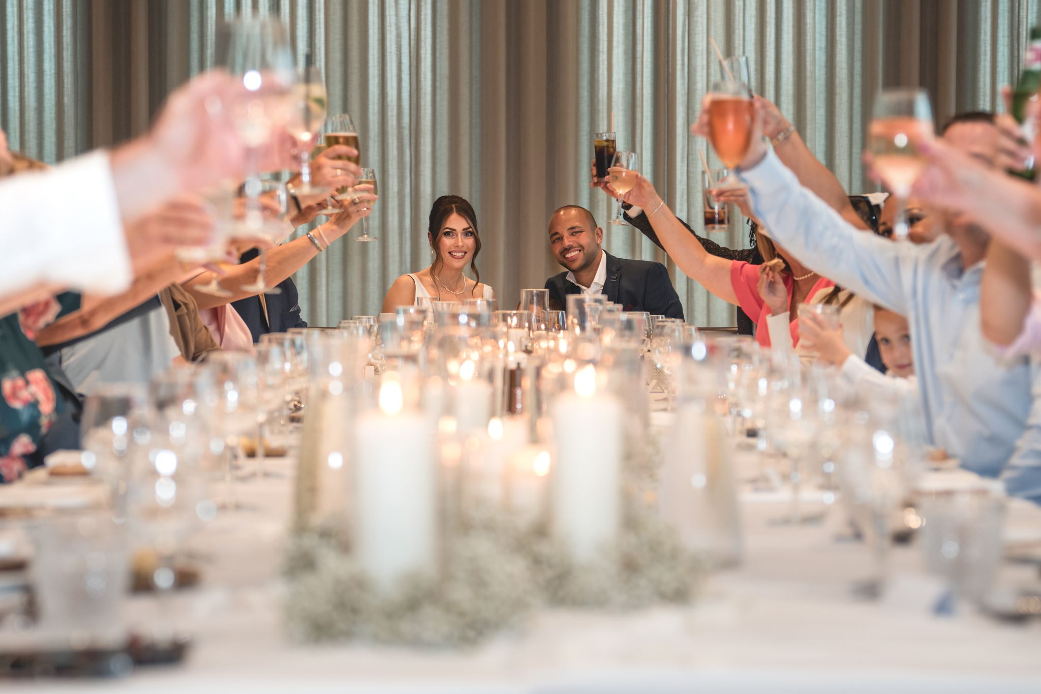Newlyweds smiling through a toast with their guests