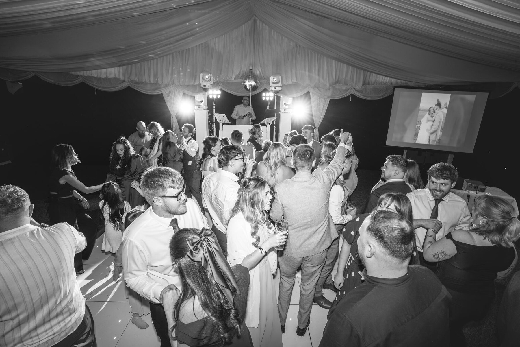 A packed wedding dance floor beneath the lights